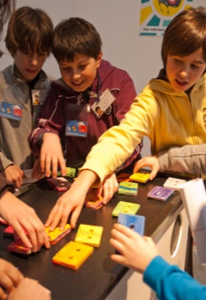 Kinderen leggen samen gekleurde blokjes op tafel
